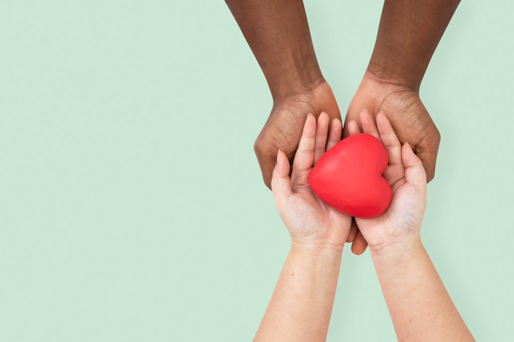 l'immagine mostra due mani che insieme mantengono un cuore rosso