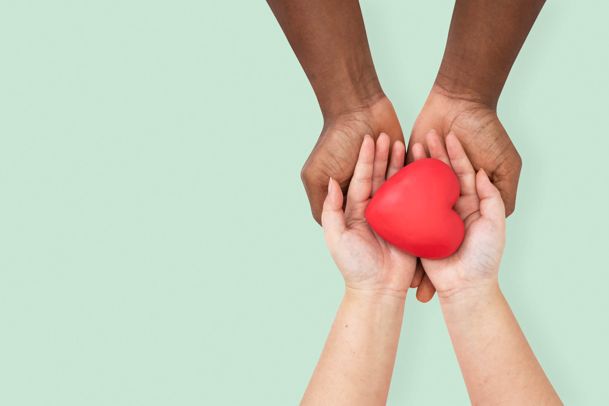 l'immagine mostra due mani che insieme mantengono un cuore rosso