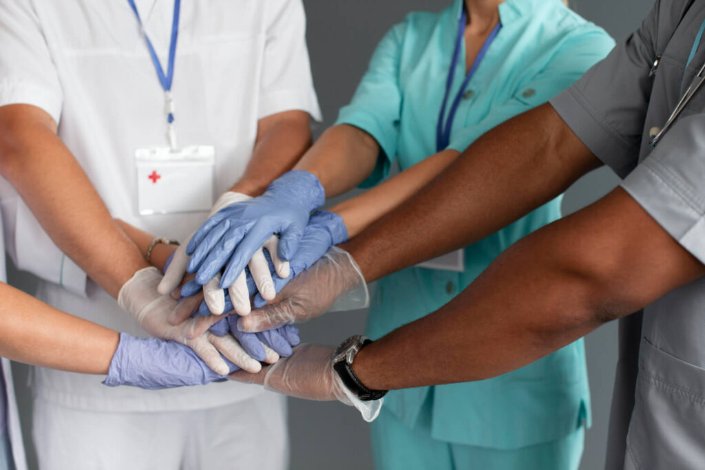Infermieri e medici che uniscono le mani in simbolo di collaborazione